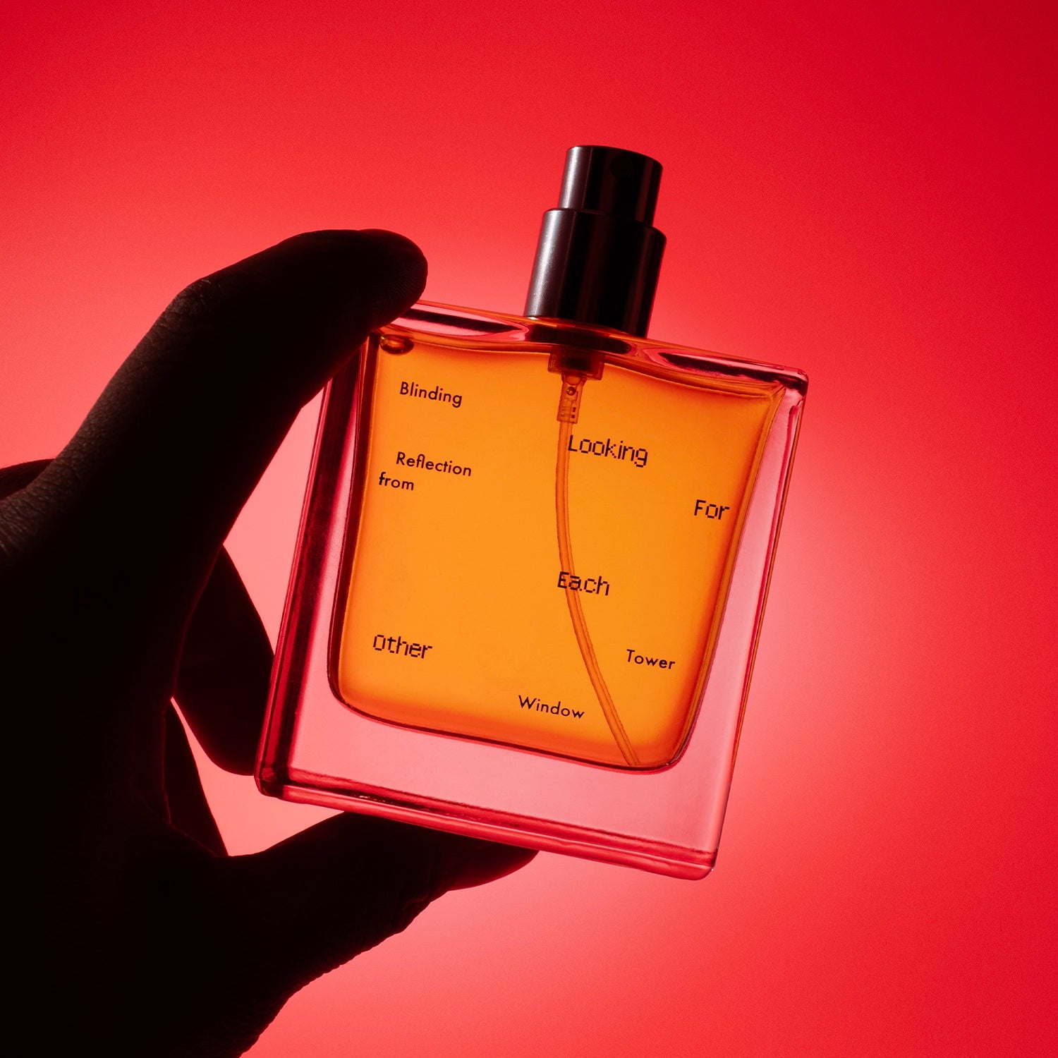 Blinding Reflection from Tower Window perfume held against a radiant red backdrop, showcasing its amber botanical liquid and bold silhouette.
