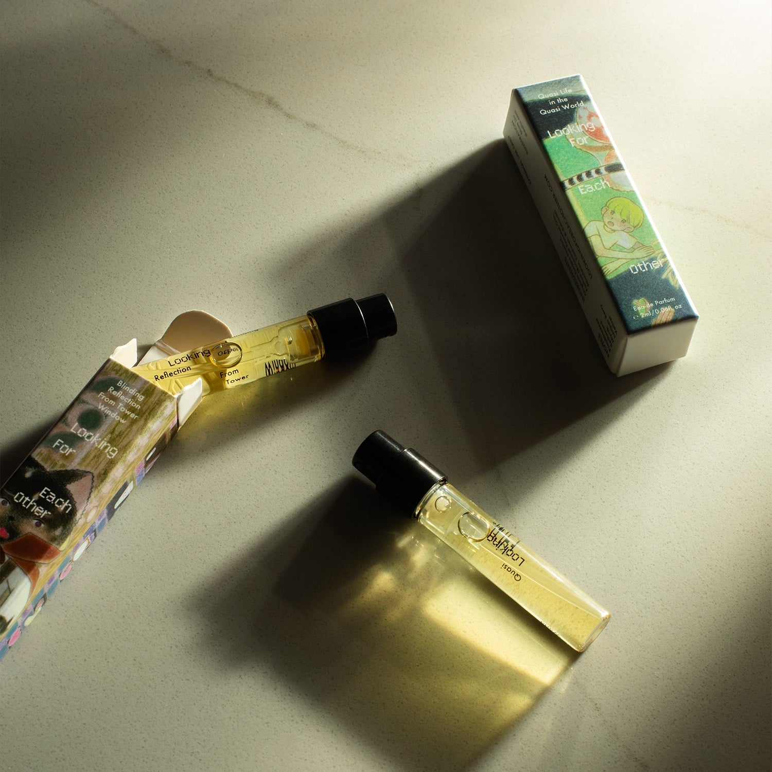 Discovery Duo botanical perfumes by Looking for Each Other, featuring two 2ml glass vials—Quasi Life in the Quasi World and Blinding Reflection from Tower Window—set on a sunlit stone surface with illustrated outer packaging casting soft shadows.
