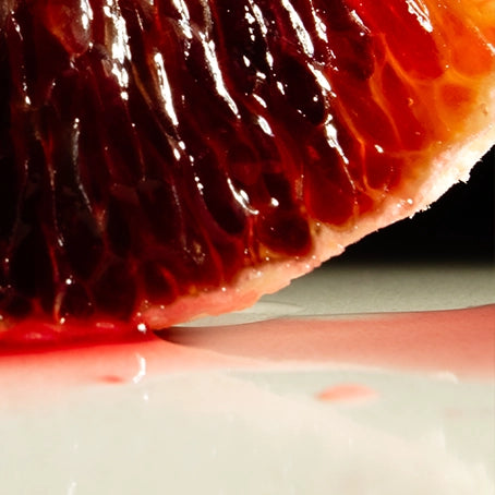 A glistening blood orange viewed close-up—illustrating the raw, plant-based ingredients used in every Looking for Each Other scent.