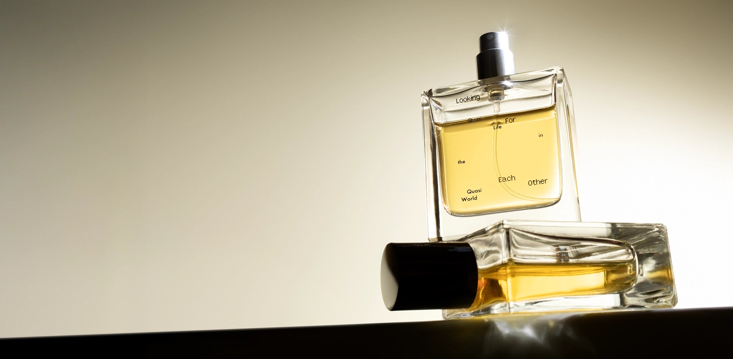 Quasi Life in the Quasi World by Looking for Each Other — clean, synthetic-free fragrance in glass bottles glowing under soft golden light.