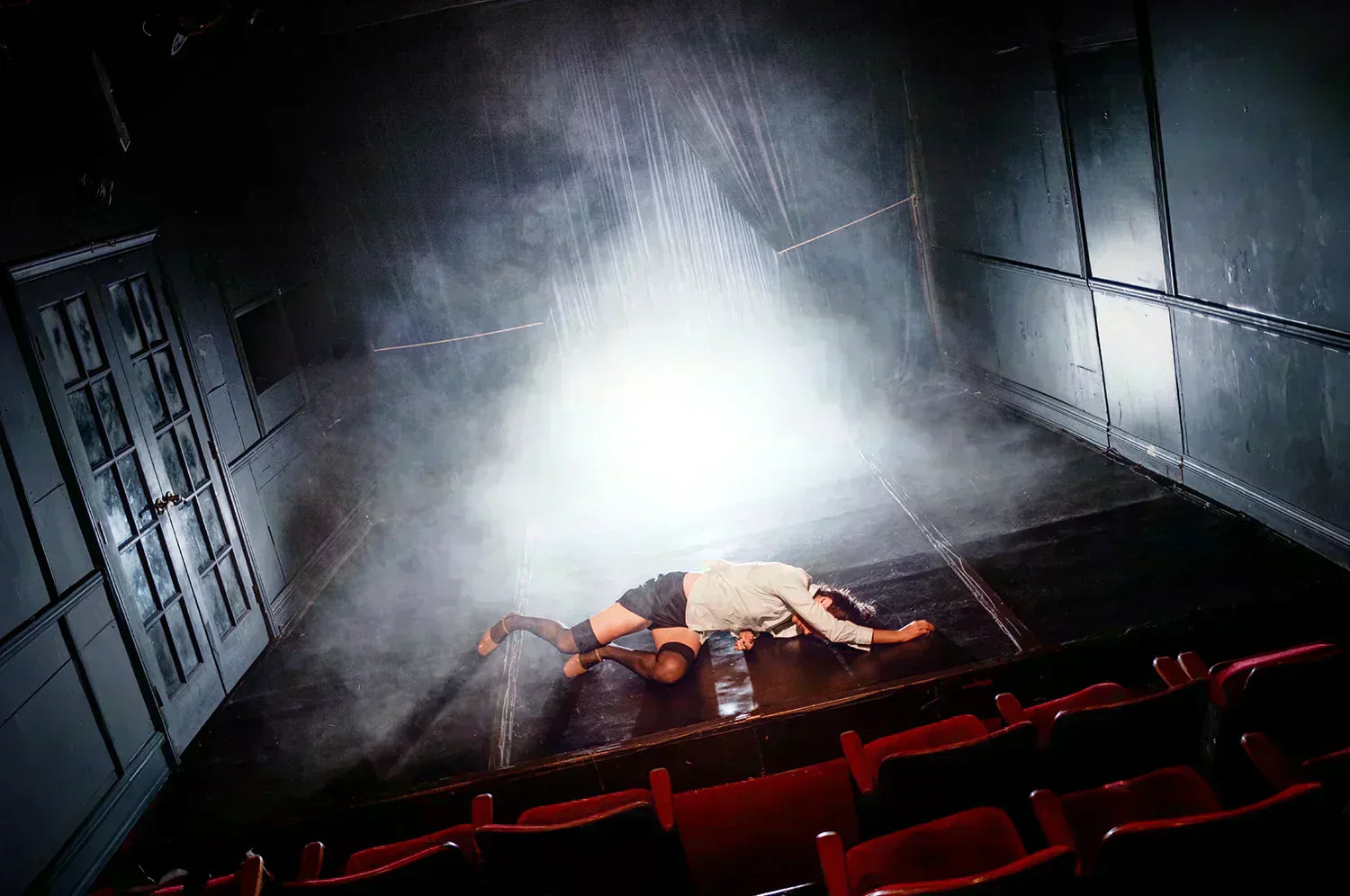 Jean Coleman collapsed onstage in a smoky theater, spotlight behind her, photographed for Looking For Each Other editorial.